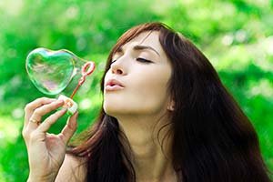 Woman Blowing Heart Shaped Bubble